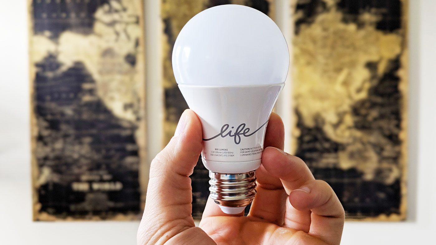 Hand holding a C-Life by GE smart bulb